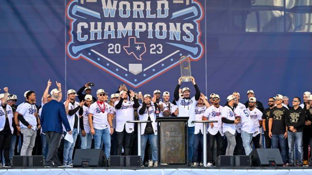 Texas Rangers starting pitcher Andrew Heaney raises the trophy during the celebration outside of the ballpark after the World Series championship parade at Globe Life Field.